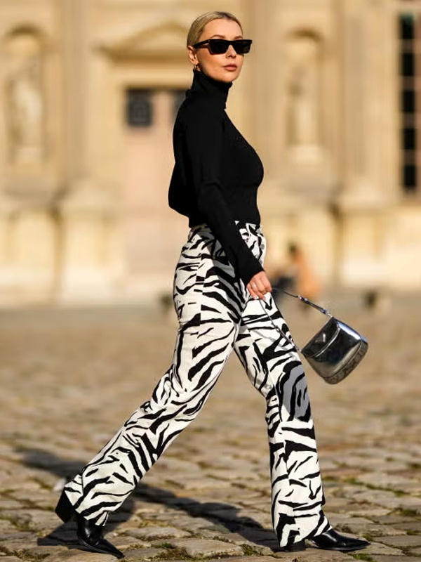 Trendy outfit pairing black full-sleeve turtleneck with bold black and white zebra print wide-leg trousers