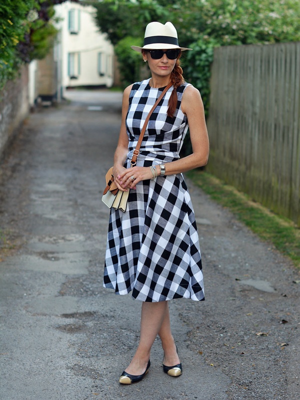 Summer black and white gingham check Bardot off-shoulder dress styled with white sun hat and flats