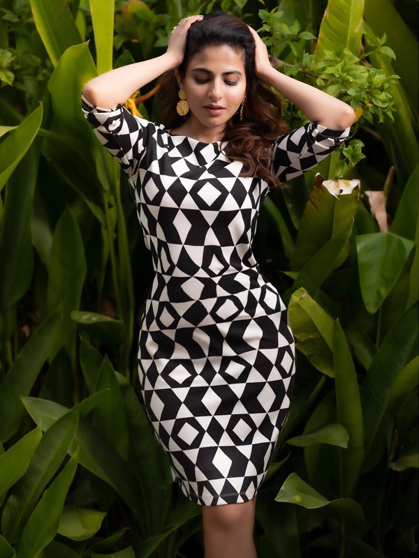 Iswarya Menon in black and white abstract print bodycon knee-length dress with gold earring accessories
