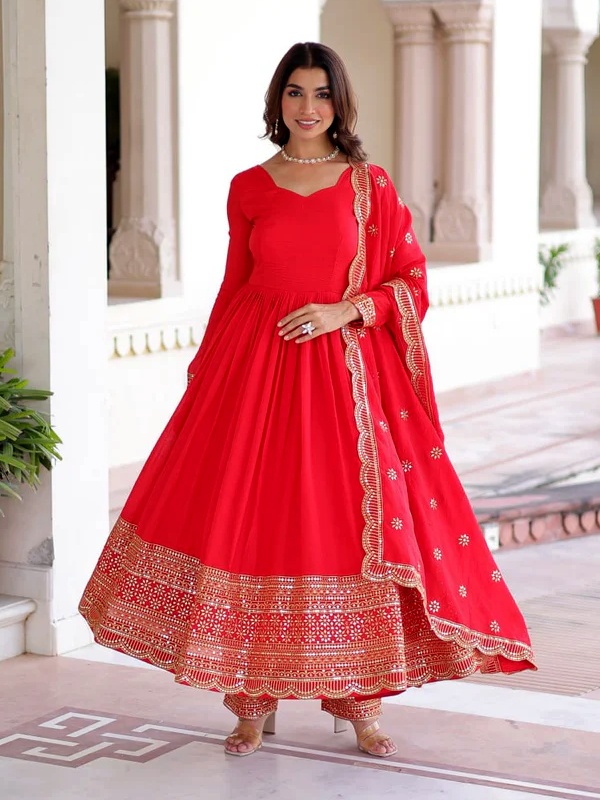 Woman wearing a red silk gown with sequin embroidery, full sleeves and a V-neck, paired with matching leggings, perfect for a festive event.