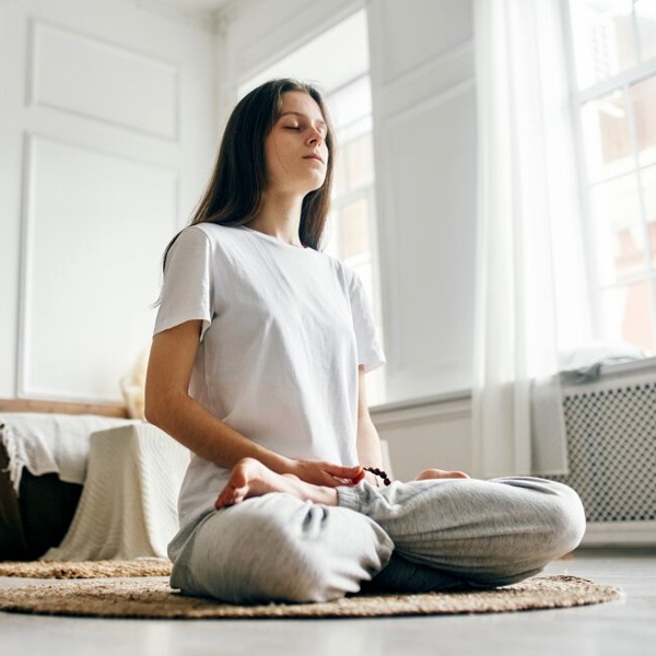 Fashion designer practicing mindful meditation in peaceful setting to clear mental creative blocks