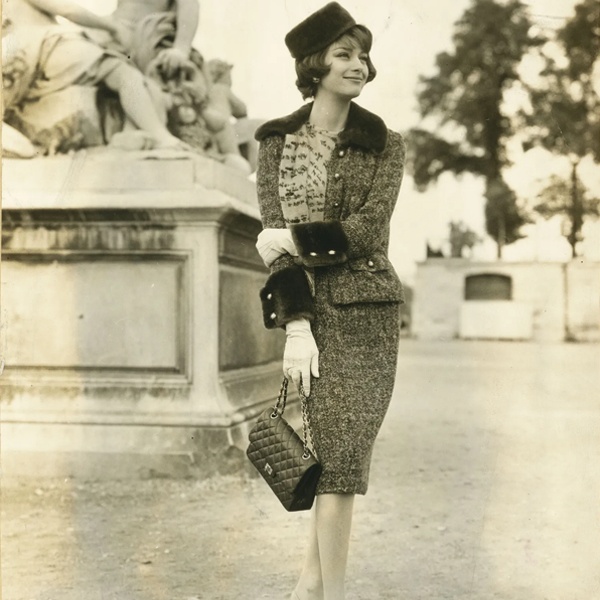 Coco Chanel revolutionary 1950's signature suit featuring A-line skirt paired with braid-trimmed cardigan-style jacket in soft tweed liberating women from restrictive Victorian clothing