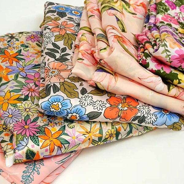 Close-up of various floral motifs including roses and lilies on fabric showing design pattern elements