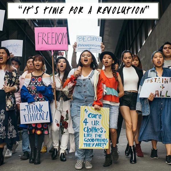 Group protesting for ethical fashion with cultural appreciation signs