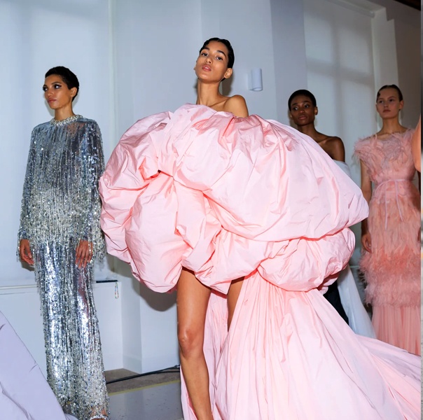 Models backstage in dramatic couture highlighting modern influences
