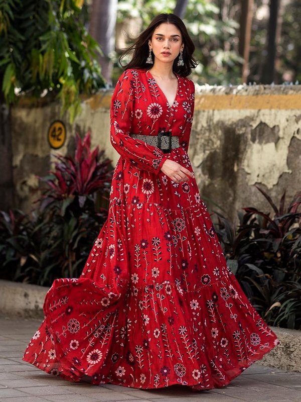 Bollywood actress Aditi Rao Hydari wearing red bohemian floral maxi dress with flowing skirt, silver layered necklaces and bangles in modern boho chic style Bollywood actress Aditi Rao Hydari wearing red bohemian floral maxi dress with flowing skirt, silver layered necklaces and bangles in modern boho chic style