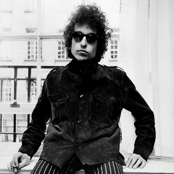 Bob Dylan understated hippie fashion in simple denim shirt, worn-in jacket, bell-bottom jeans and leather boots representing minimalist bohemian style Bob Dylan understated hippie fashion in simple denim shirt, worn-in jacket, bell-bottom jeans and leather boots representing minimalist bohemian style
