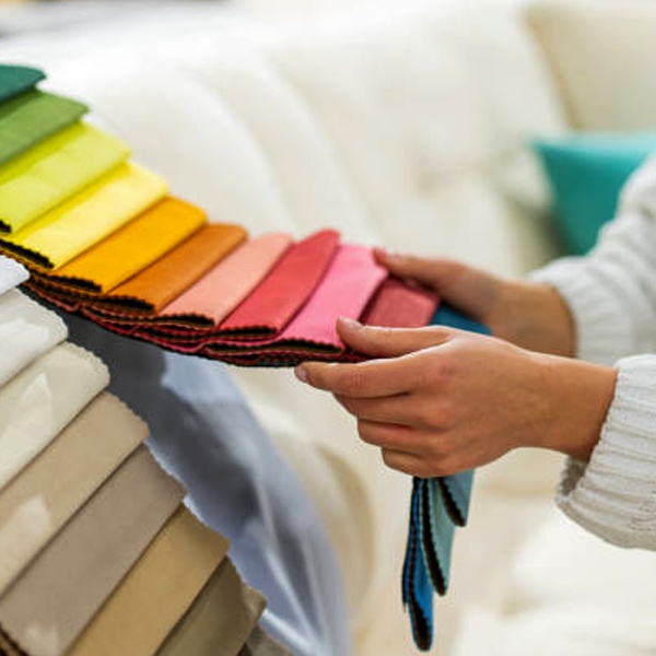 Various fabric samples and textiles being examined for fashion design showing texture, drape and material properties selection process Various fabric samples and textiles being examined for fashion design showing texture, drape and material properties selection process