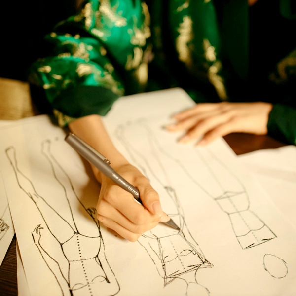 Fashion designer sketching clothing designs and illustrations showing the creative visualization process in fashion design Fashion designer sketching clothing designs and illustrations showing the creative visualization process in fashion design
