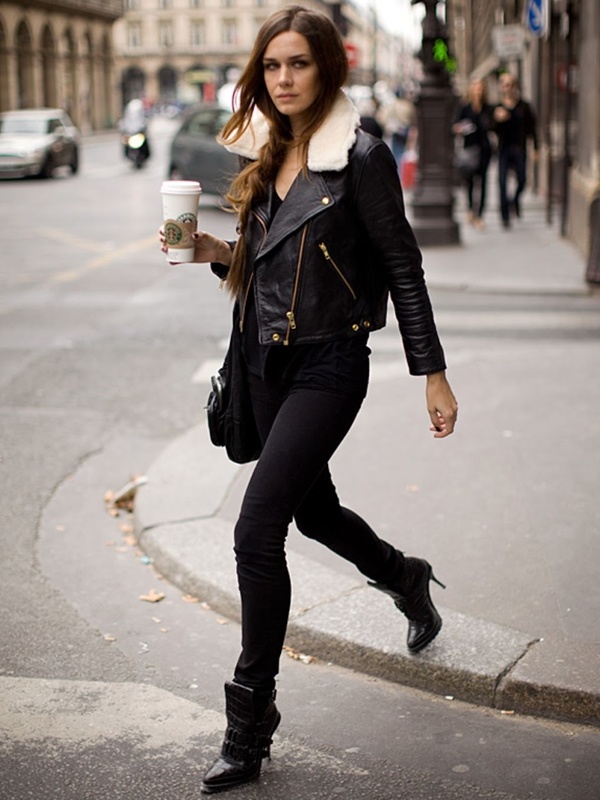 Woman in sleek all-black outfit with shearling-lined leather biker jacket, black skinny jeans and ankle boots for urban chic style