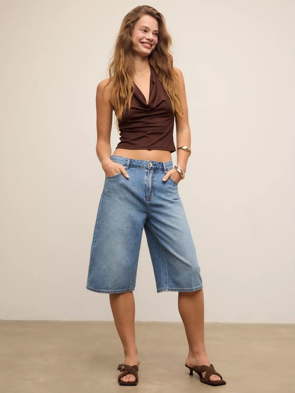 Woman in medium blue wide-leg denim jorts with brown halter top - relaxed casual summer fashion