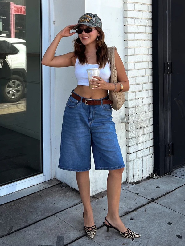 Woman wearing classic medium blue high-waist wide-leg jorts with leather belt - timeless street fashion