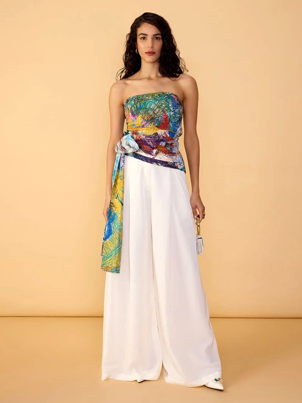 Abstract scribble print strapless top with side bow sash paired with high-waisted white wide-leg palazzo pants. Abstract scribble print strapless top with side bow sash paired with high-waisted white wide-leg palazzo pants.
