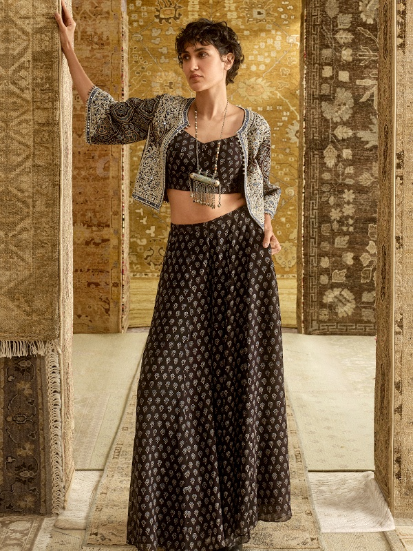 Black Ajrakh printed crop top and palazzo pants paired with a mirror-work embroidered jacket. Black Ajrakh printed crop top and palazzo pants paired with a mirror-work embroidered jacket.