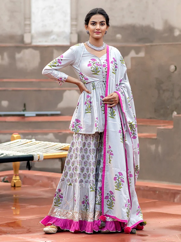 Grey floral printed sharara set featuring a peplum top, gota work details and a pink ruffled hem. Grey floral printed sharara set featuring a peplum top, gota work details and a pink ruffled hem.