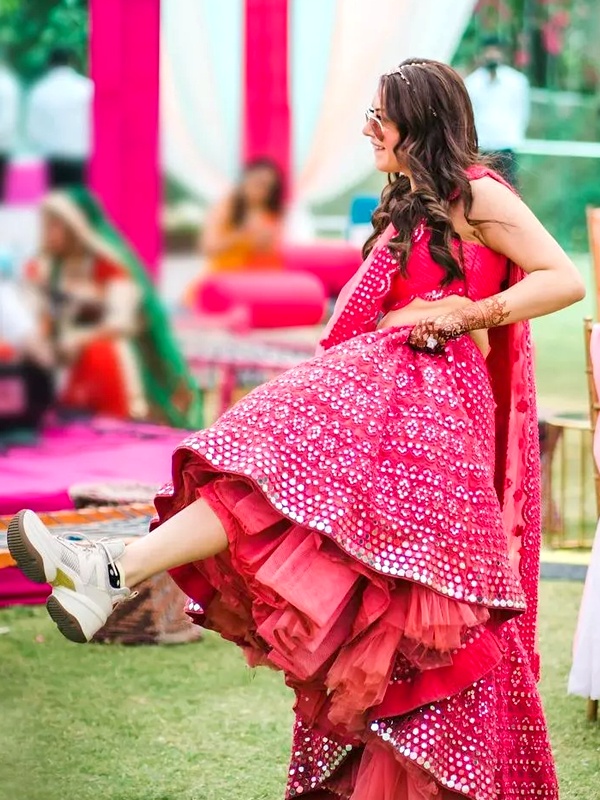 Traditional lehenga paired with white chunky sneakers showcasing modern fusion footwear styling
