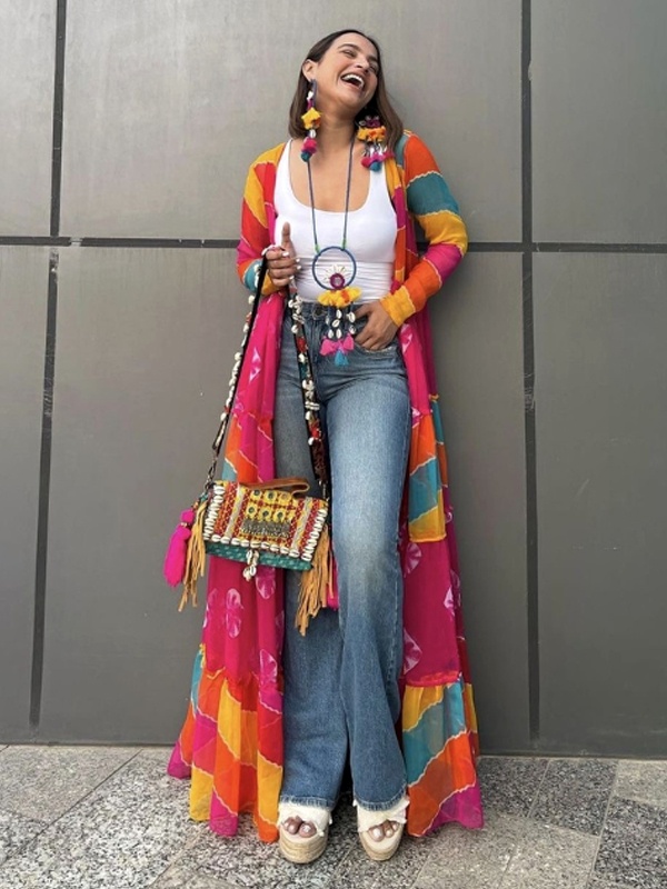 Colorful leheriya print long shrug worn over a white tank top and blue jeans with boho tassel accessories. Colorful leheriya print long shrug worn over a white tank top and blue jeans with boho tassel accessories.