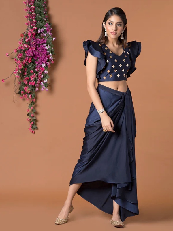 Navy blue draped skirt set featuring a ruffle sleeve crop top with geometric embellishments and an asymmetric hemline. Navy blue draped skirt set featuring a ruffle sleeve crop top with geometric embellishments and an asymmetric hemline.