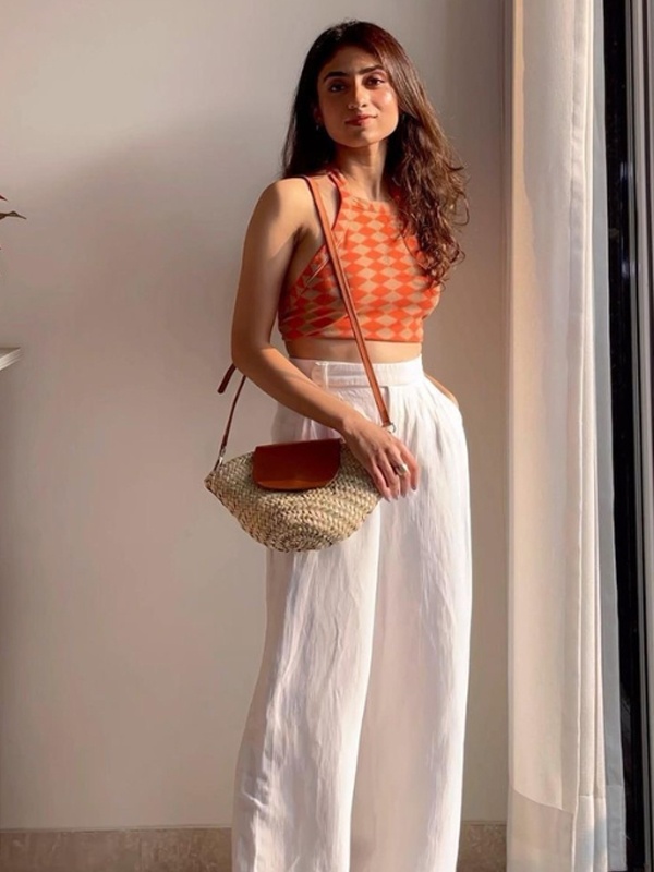 Orange checkered halter neck crop top paired with white high-waisted wide-leg linen pants. Orange checkered halter neck crop top paired with white high-waisted wide-leg linen pants.
