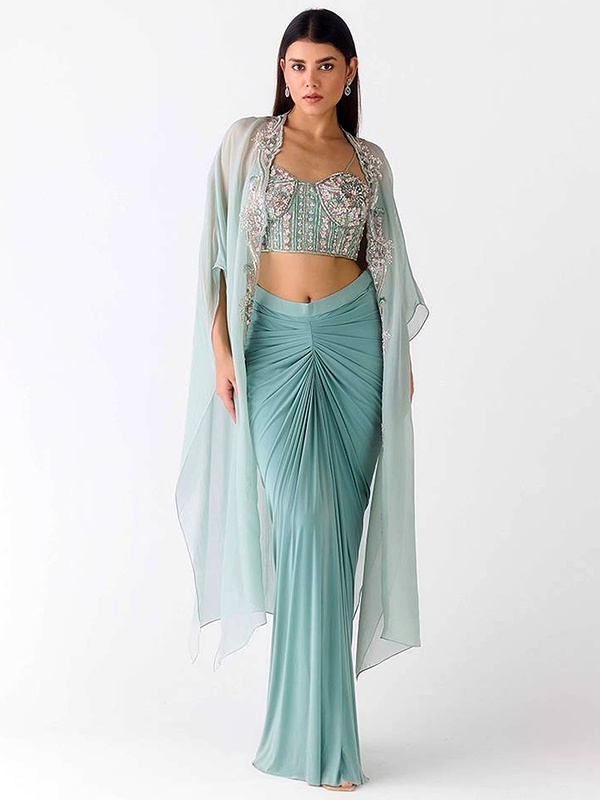 Pastel blue draped skirt set with an embroidered bustier and a sheer open-front cape. Pastel blue draped skirt set with an embroidered bustier and a sheer open-front cape.