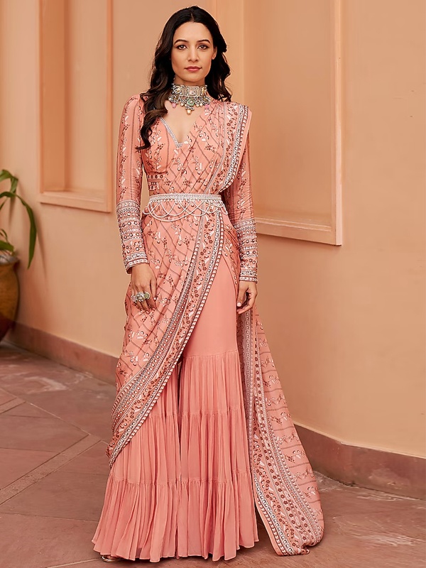 Peach georgette sharara saree with floral prints, embroidery and a beaded waist belt. Peach georgette sharara saree with floral prints, embroidery and a beaded waist belt.