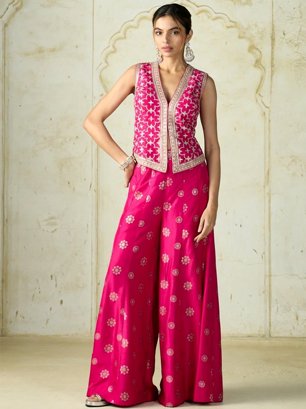 Rani pink sleeveless vest with intricate embroidery paired with wide-leg pants featuring small floral motifs. Rani pink sleeveless vest with intricate embroidery paired with wide-leg pants featuring small floral motifs.