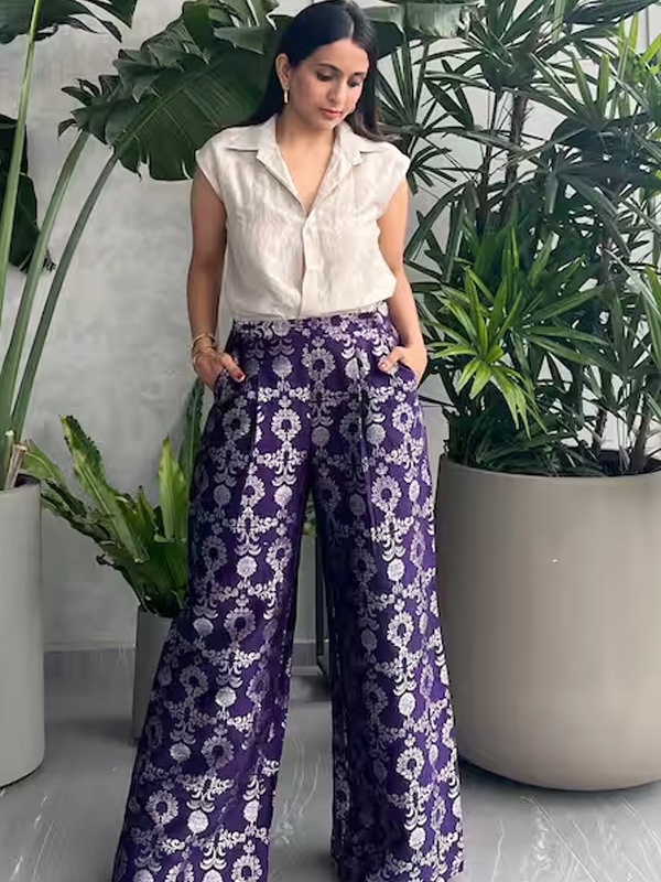 Silver cap-sleeve shirt paired with purple floral brocade wide-leg pants featuring a spread collar. Silver cap-sleeve shirt paired with purple floral brocade wide-leg pants featuring a spread collar.