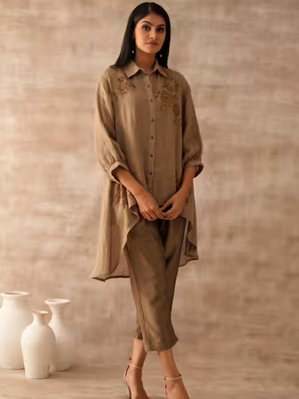 Woman wearing beige embroidered kurta with asymmetric hem and matching trousers