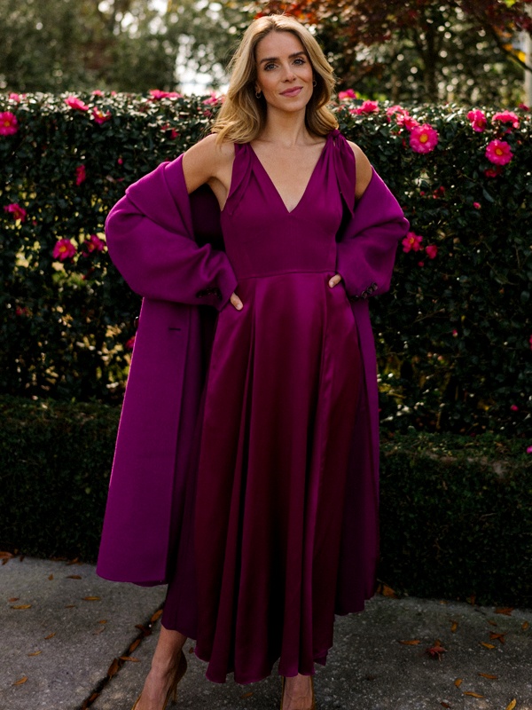 Woman wearing magenta cold shoulder midi dress with bishop sleeves and V neckline
