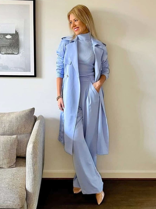 Woman wearing sky blue ribbed turtleneck with trench coat and wide leg trousers