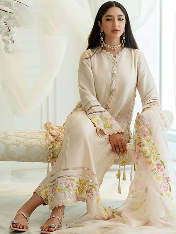 Woman wearing a cream Lucknowi kurti with colorful floral embroidery and lace details, paired with matching pants. Woman wearing a cream Lucknowi kurti with colorful floral embroidery and lace details, paired with matching pants.