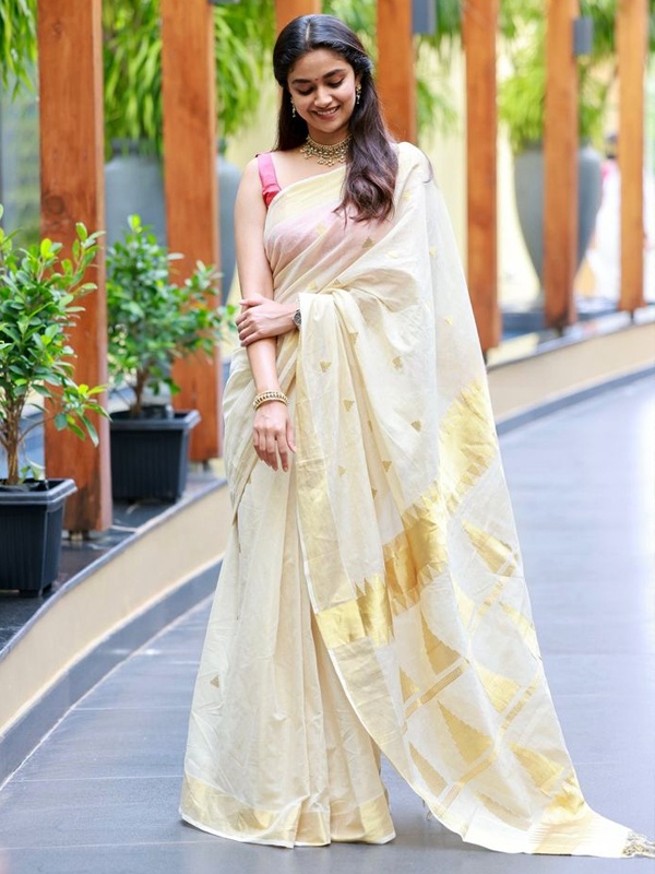 Cream saree with gold accents on actress Keerthy Suresh, highlighting traditional beauty. Cream saree with gold accents on actress Keerthy Suresh, highlighting traditional beauty.