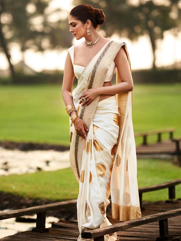 Cream saree with gold patterns on actress Malavika Mohanan, showcasing traditional elegance. Cream saree with gold patterns on actress Malavika Mohanan, showcasing traditional elegance.