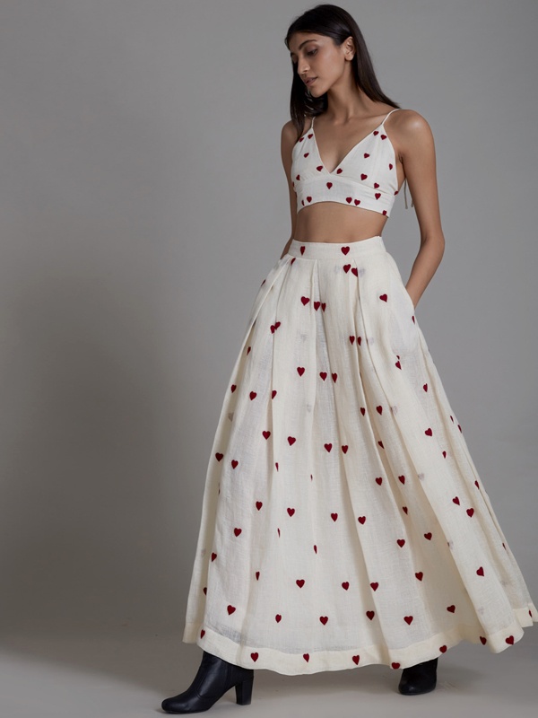 Women wearing a white dress with red heart patterns, black ankle boots and a sleek hairstyle. Women wearing a white dress with red heart patterns, black ankle boots and a sleek hairstyle.