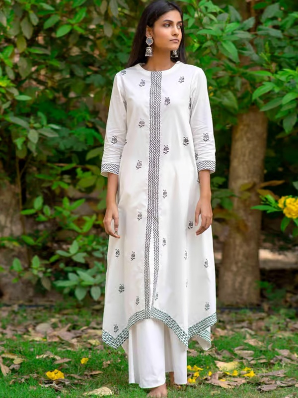 Woman wearing a white kurta with palazzo pants, featuring checkered trim and floral embroidery. Woman wearing a white kurta with palazzo pants, featuring checkered trim and floral embroidery.