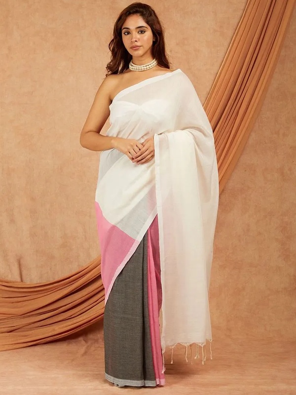 Woman draped in a handloom cotton saree with white, pink and grey color blocks, accessorized with a pearl choker. Woman draped in a handloom cotton saree with white, pink and grey color blocks, accessorized with a pearl choker.