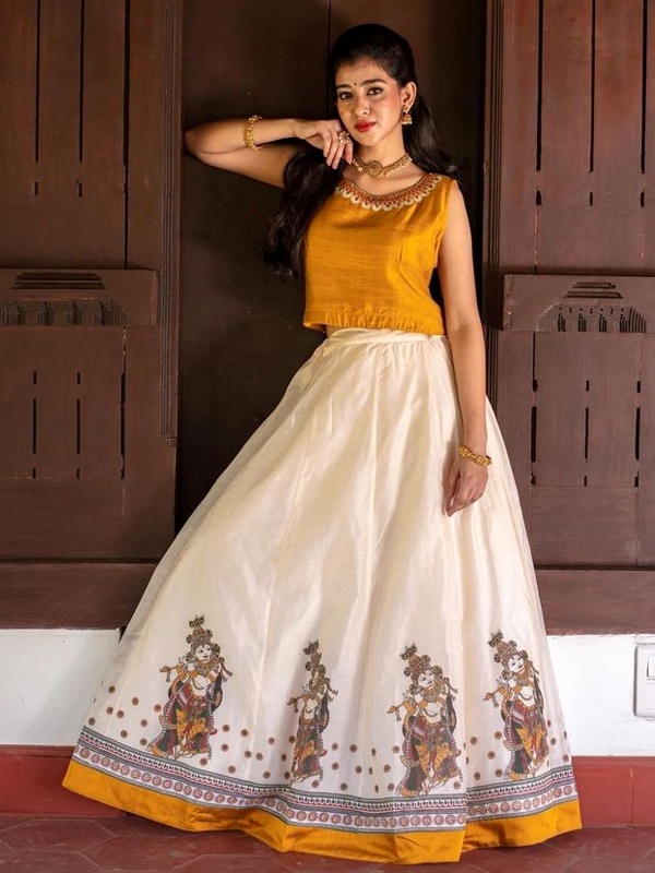 Woman in yellow crop top and white Ganesha print skirt for Onam. Woman in yellow crop top and white Ganesha print skirt for Onam.
