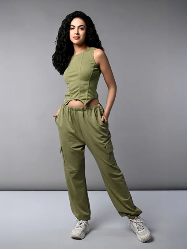 College student styling corset crop top with matching parachute pants and white sneakers for monochrome streetwear look