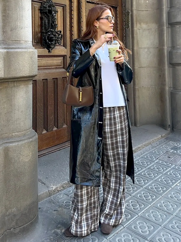Fall-ready plaid parachute pants with white shirt, long black leather jacket, brown boots and shoulder bag for stylish campus look