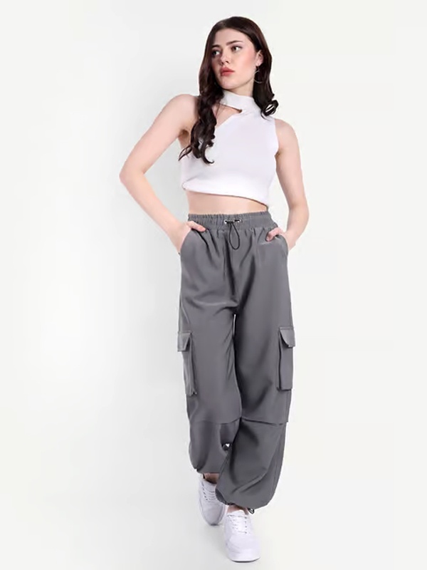 Minimalist grey parachute pants with plain white sleeveless crop top and white sneakers for simple everyday college style