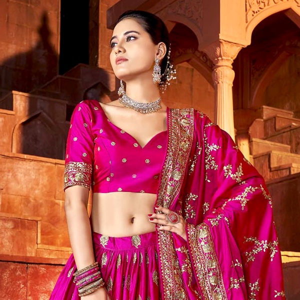 Pink outfit balanced with gold metallic accessories including belt, clutch and heels