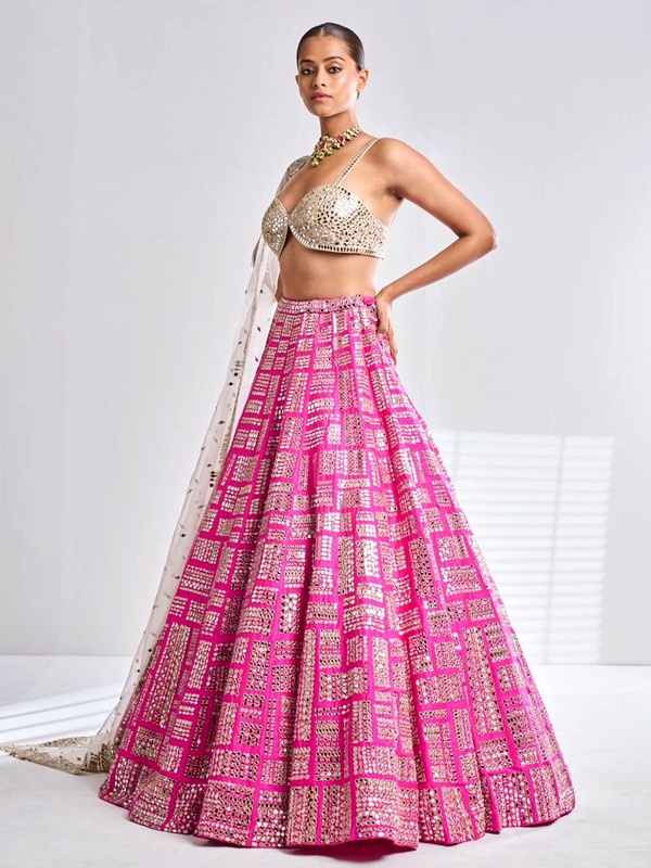 Vibrant pink lehenga featuring bold geometric mirror work and silver-toned bralette blouse