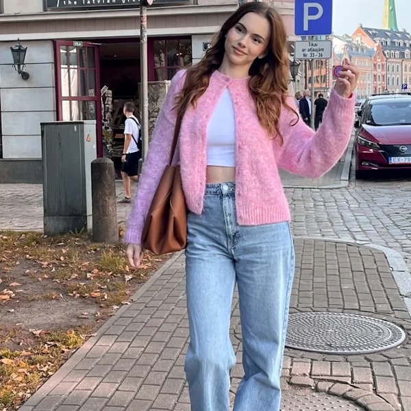 Pink knit sweater layered over white shirt for comfortable winter casual wear