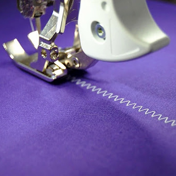 Zigzag stitch formation showing needle moving side to side while feed dogs pull fabric forward Zigzag stitch formation showing needle moving side to side while feed dogs pull fabric forward