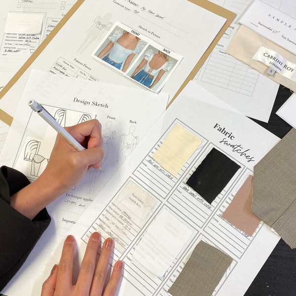 Fashion student planning swatch book layout with different sized fabric samples, cardstock, and measurement tools Fashion student planning swatch book layout with different sized fabric samples, cardstock, and measurement tools
