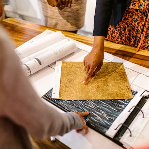 Fashion designer presenting fabric swatches to clients and using swatch book for supplier meetings and collection development Fashion designer presenting fabric swatches to clients and using swatch book for supplier meetings and collection development