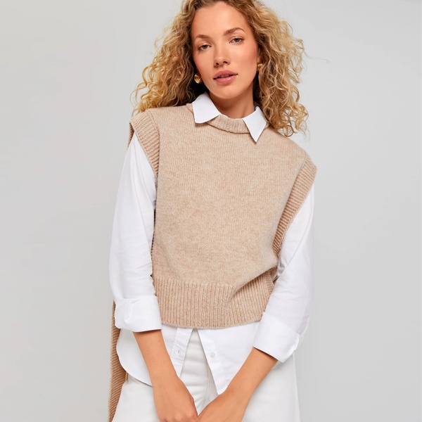 Warm earth tone outfit combining camel brown sweater vest with cream colored shirt ideal for autumn winter styling
