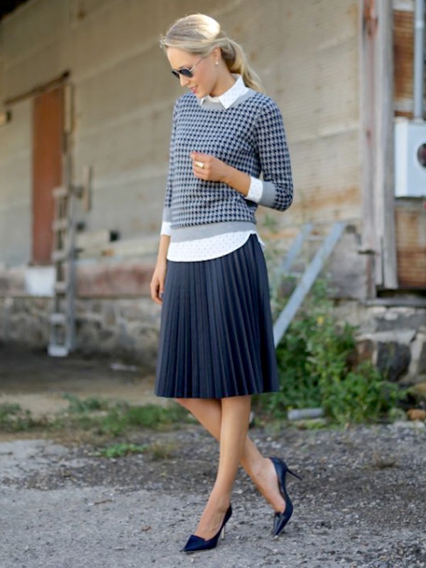 Feminine preppy outfit white polka dot shirt under grey checkered three-quarter sleeve cardigan with beige pleated midi skirt and black pointed heels