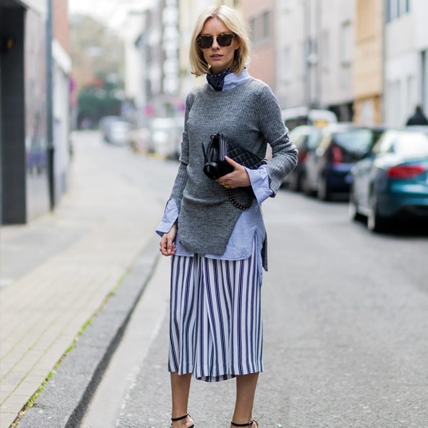 Soft romantic equestrian-inspired outfit with beige mohair sweater vest over white shirt styled with checked plaid midi skirt and tan suede ankle boots