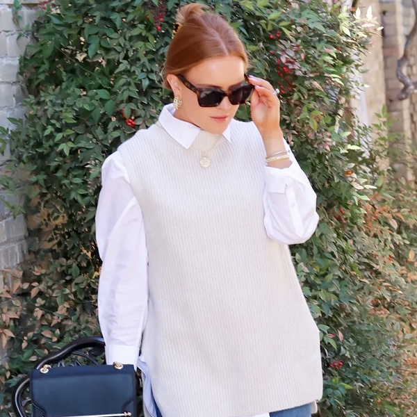 Minimalist monochrome beige outfit featuring tonal sweater vest layered over matching beige shirt for clean sophisticated aesthetic